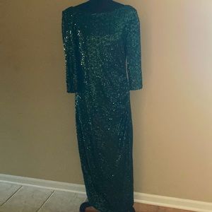 Sparkly, green sequin gown. It’s backless with hanging cape detail.